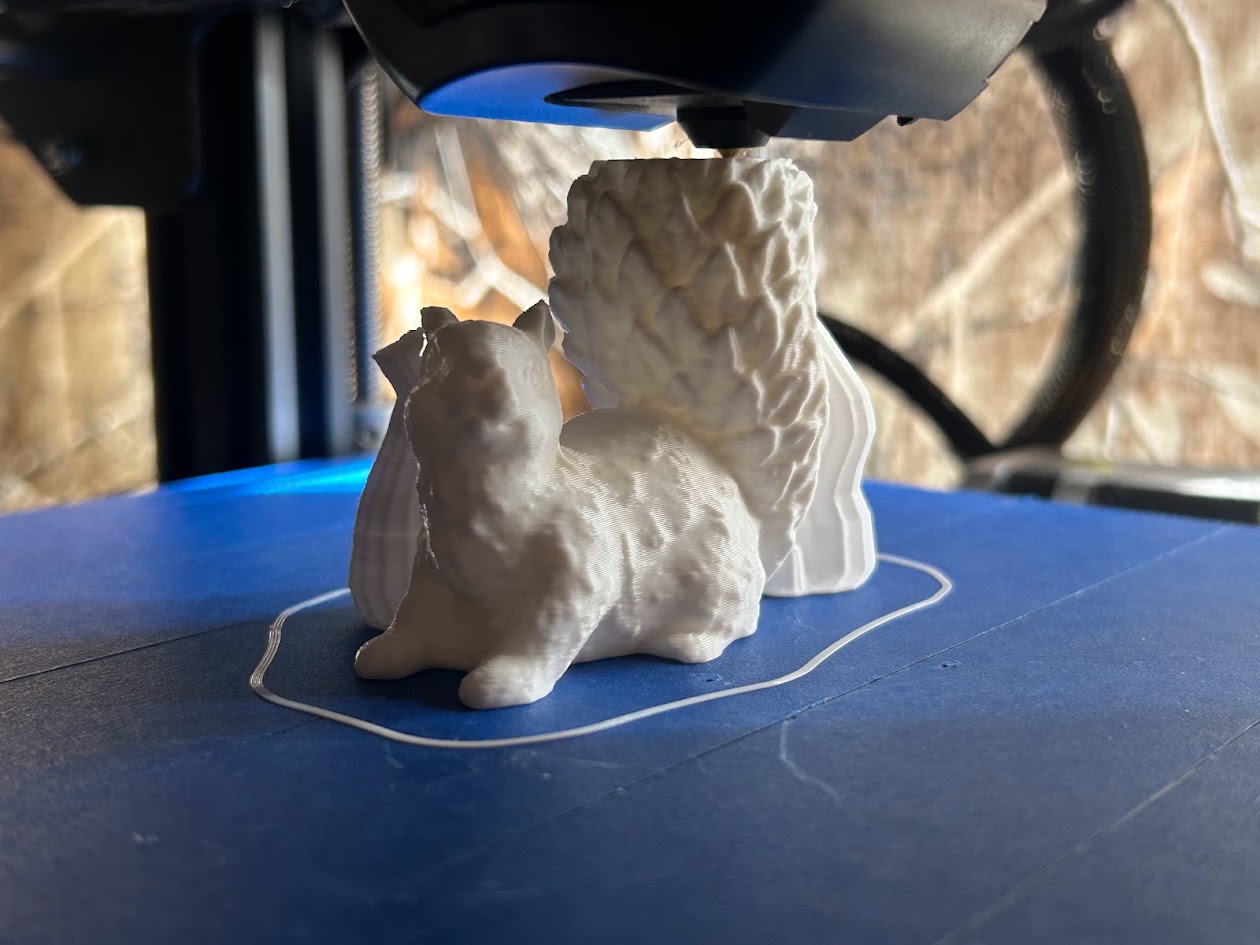 White 3D-printed squirrel taking shape on a printer bed
